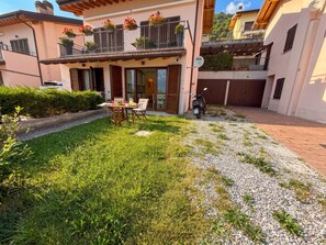 Il s’agit d’une propriété résidentielle dotée d’une terrasse, d’une table à manger et d’une moto garée à l’extérieur.