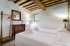 A room with two beds, a wooden wardrobe, a mirror, and a window. - Hostdomus - Villa Celestia (Alassio)