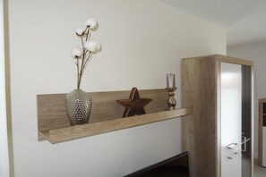 Ein Holzboden mit Dekorationsobjekten, darunter eine Vase, ein sternförmiges Objekt und eine Kerze.