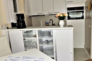 A compact kitchen with a coffee maker, a sink, and a vase with flowers. - Holiday apartment with 2 bedrooms (Schönberger Strand)