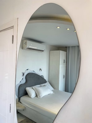 A bedroom with a bed, an air conditioning unit, a wardrobe, and a mirror reflecting the room. - AB N1008 Nile view std with a Jaccuzi (Giza Governorate)