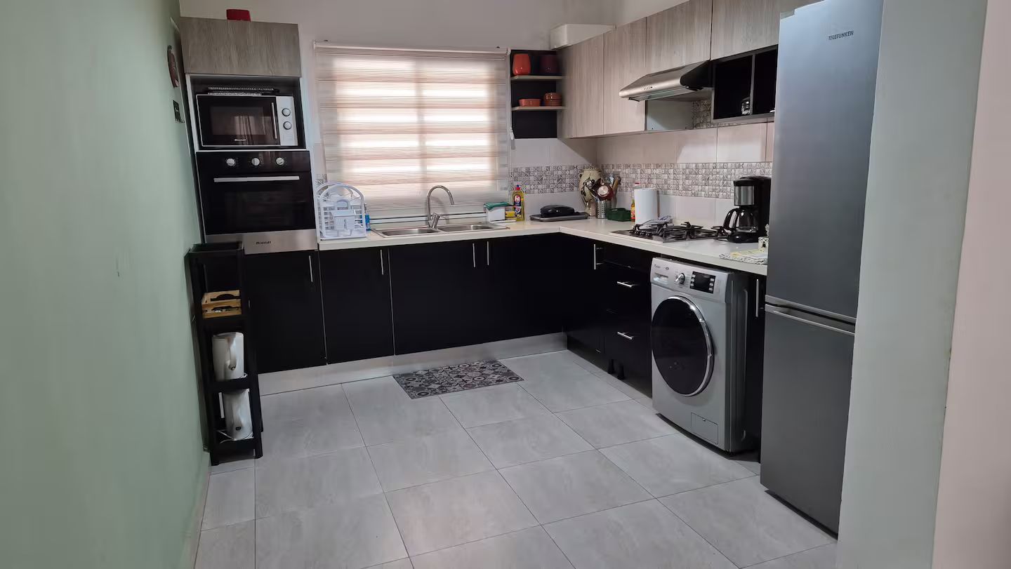 Cocina compacta con horno integrado, lavadora y refrigerador.