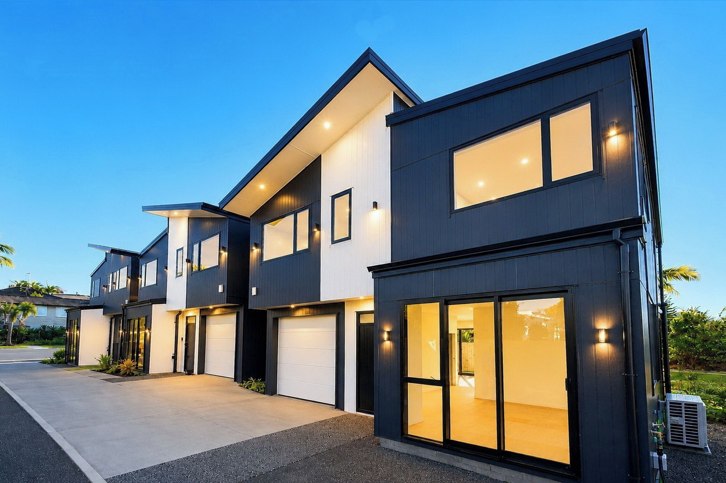 En moderne boligbygning i to etager med store vinduer og garage.