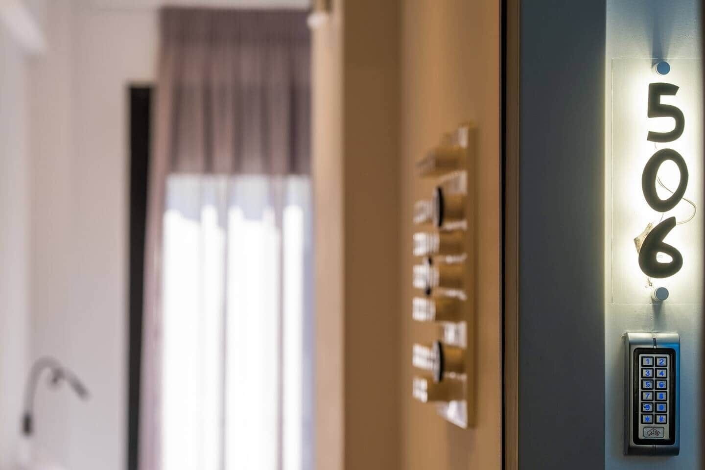 A hotel room with a digital keypad and a number display showing '506'.
