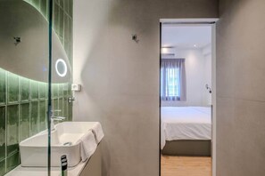 A modern bathroom with a glass shower enclosure, a white sink, and a towel. - Pop Urban Escape near the center (Athens)