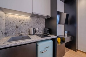 A modern kitchen with a built-in sink, a coffee maker, and a compact refrigerator. - Pop Urban Escape near the center (Athens)