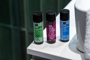 Three bottles of Body Farm hair care products on a white shelf. - Pop Urban Escape near the center (Athens)