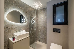 A modern bathroom with a freestanding bathtub, a glass-enclosed shower, and a vanity with a mirror. - Playful Design close to Athens Highlights (Athens)