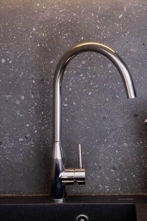 A kitchen sink with a modern faucet and a visible drain. - Color Pop Studio with city Vibes near Center (Athens)