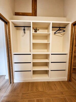 A walk-in closet with multiple shelves and hanging space.