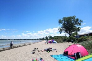 Une plage avec des tentes et des gens qui se détendent.