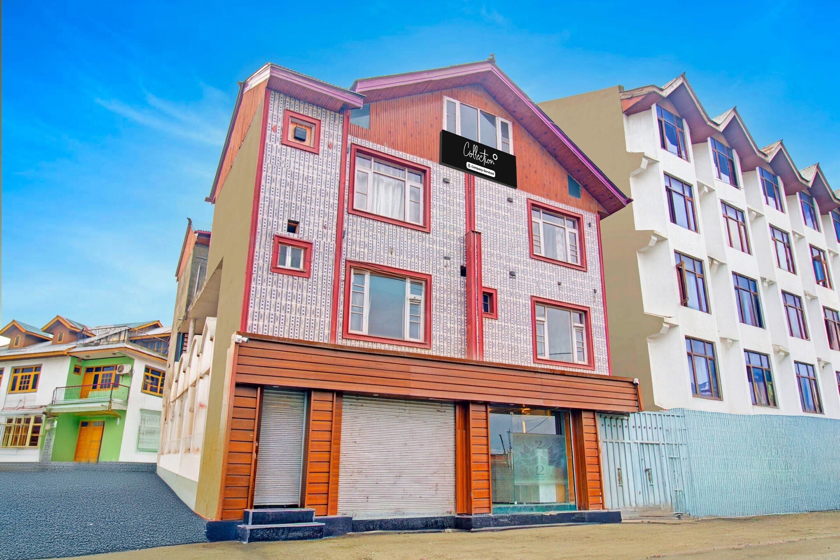 A multi-story building with a distinctive facade, featuring a mix of patterned and plain surfaces, and a sign indicating a company service.