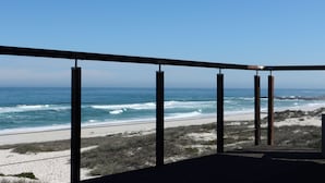 Un balcon avec vue sur l’océan et la plage.