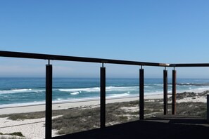 A balcony with a view of the ocean and beach. - Luxury 4 Bedroom Beachfront Villa/Private Pool & Ocean Views (Yzerfontein)