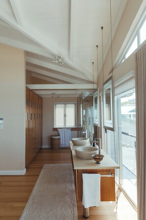 A modern bathroom with a large window, a sink, and a mirror.