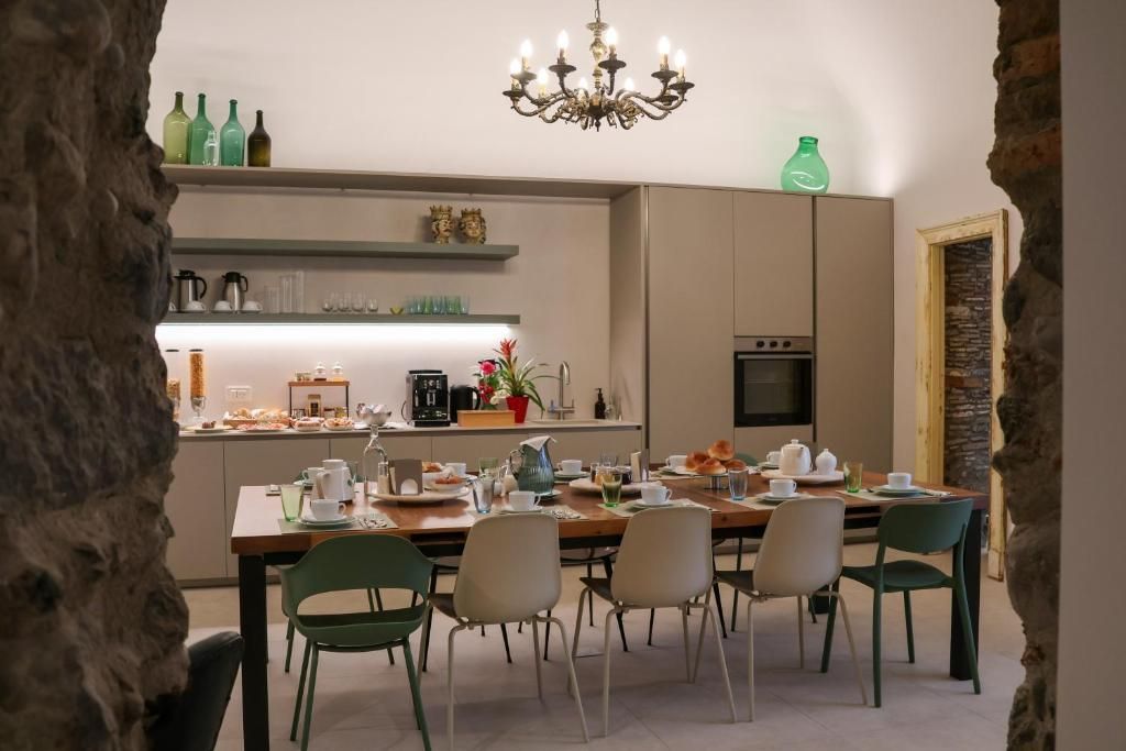Una cocina moderna con comedor, una araña y una pared de piedra.