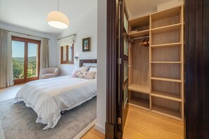 A bedroom with a large bed, a wardrobe, and a view of the outdoors. - Can Porquer, Luxury villa with a pool near the golf course (IB Pollensa)