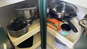 A kitchen with stainless steel pots and pans, a Tesco sandwich bag, and a jar of spread. - Pit Stop - Brooklands Weybridge Flat (Weybridge)