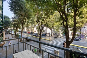 A street view with trees, a crosswalk, and parked vehicles. - Deluxe Room with Balcony, Wi-Fi & Air Conditioning (Napoli)