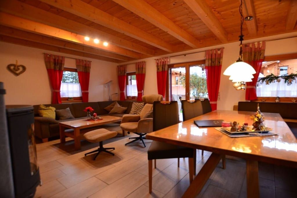 Un salon chaleureux avec un plafond en bois, un canapé, une table à manger et une cheminée.