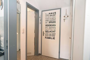 A hallway with a door featuring a German text message about family and gratitude. - Meerliebe by Flo & Kim: Your modern apartment just 300 meters from the North Sea beach (Büsum)