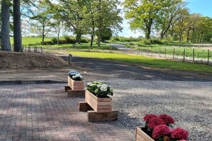 Un chemin pavé bordé de jardinières en bois remplies de fleurs.
