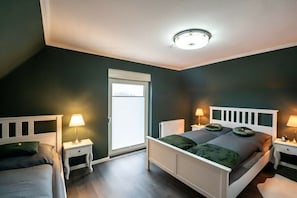 A bedroom with a white bed, two bedside tables with lamps, a window, and a ceiling light. - Country Bliss - Nordhorn (Nordhorn)