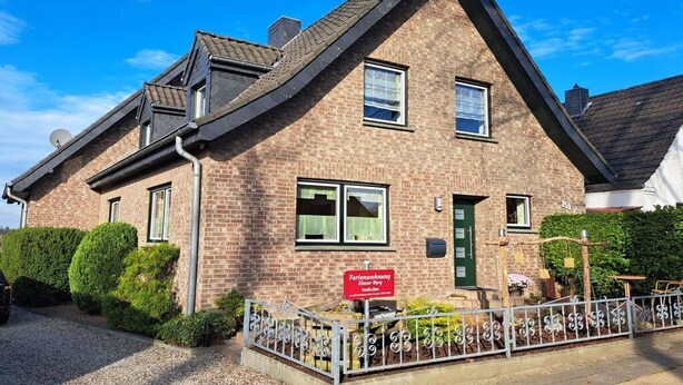A two-story brick building with a sloped roof, a green door, and a sign indicating it's a guesthouse. - Holiday apartment Klever Berg (Kleve)