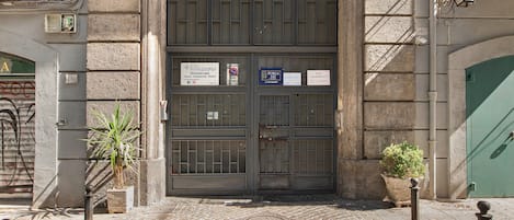 A building entrance with a double door, a sign for a dance profession, and a no parking sign.