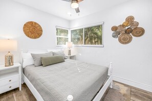Ein Schlafzimmer mit einem Bett, Nachttischen, einer Lampe und Wanddekoration.