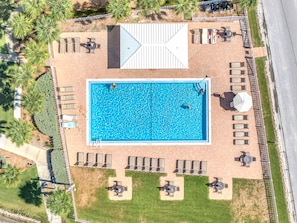 An aerial view of a swimming pool surrounded by lounge chairs and tables, with a paved deck and a white fence. - Gertrude's Siesta | 100% Private, 2-min to Beach Path! Dining & Music! Snorkeling, Sunsets! (Siesta Key)