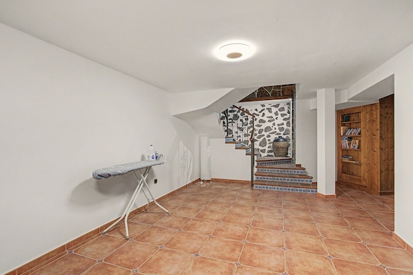 A staircase with blue and white tiles leading to a landing with a stone wall.