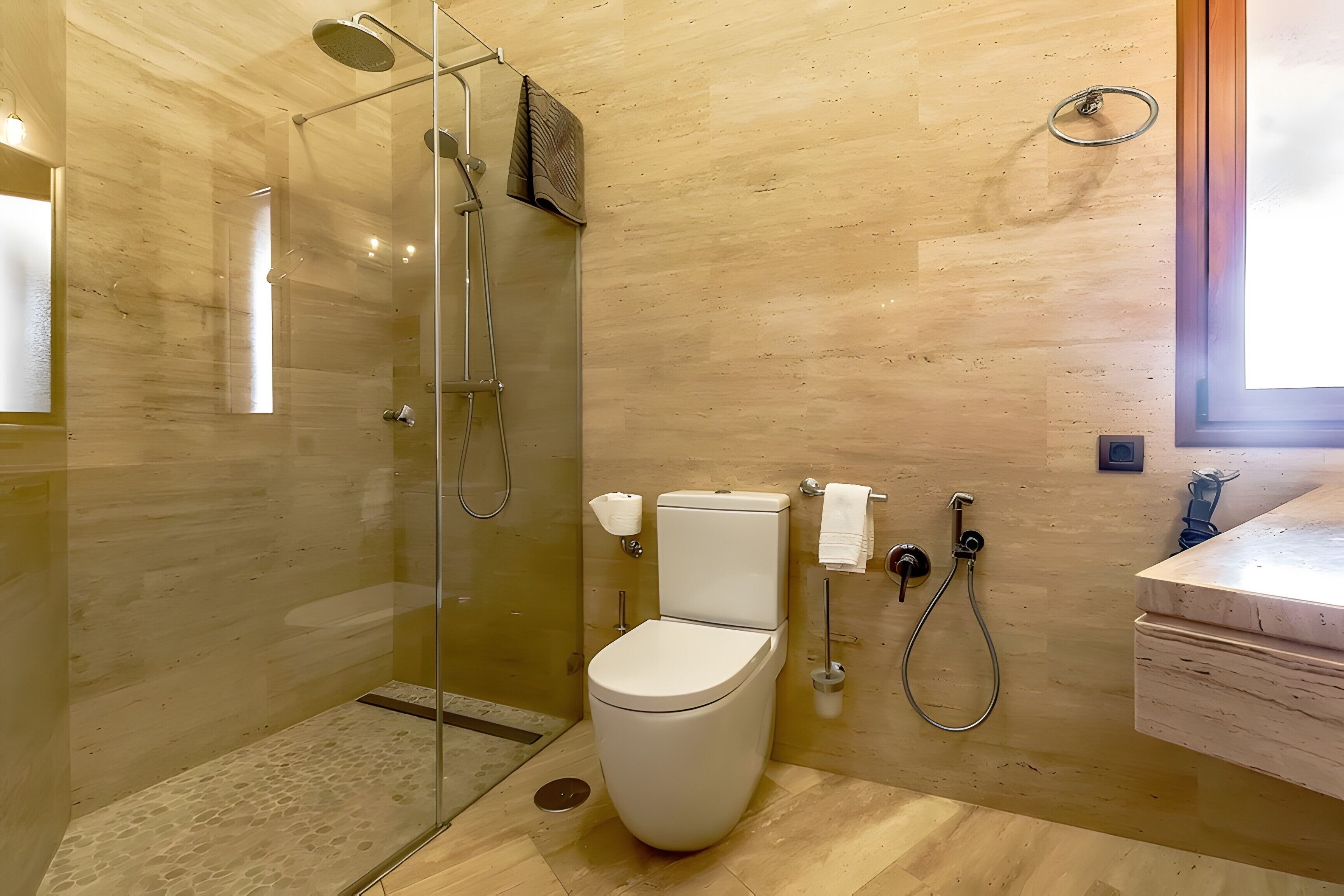 Un baño moderno con ducha de vidrio, inodoro y lavamanos.
