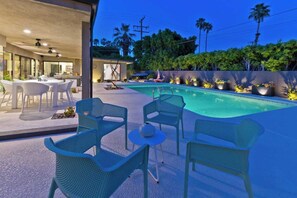 Ein Außenpoolbereich mit Sitzgelegenheiten und einer Terrasse.
