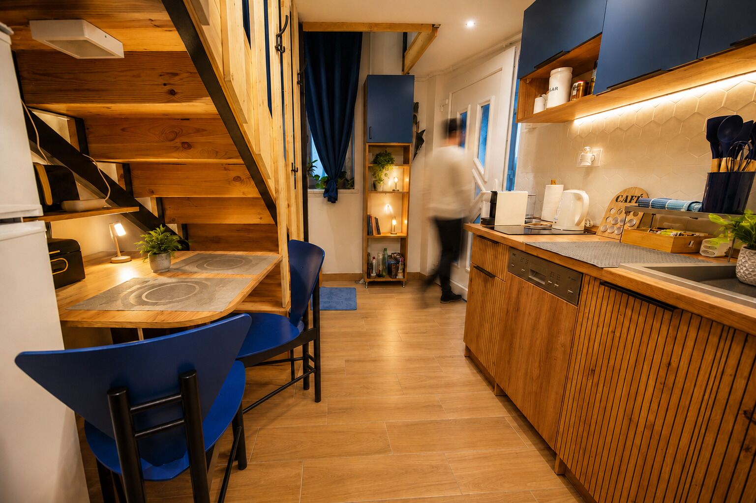 Eine moderne Küche mit Holzausstattung, einer integrierten Spülmaschine und einer Barbereich mit einer Kaffeemaschine.