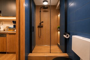 A modern bathroom with a shower, toilet, and sink. - Cozy 1-bedroom apartment in Budapest (Budapest)