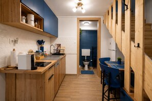 A compact kitchen with wooden cabinetry, a coffee machine, and a sink. - Cozy 1-bedroom apartment in Budapest (Budapest)