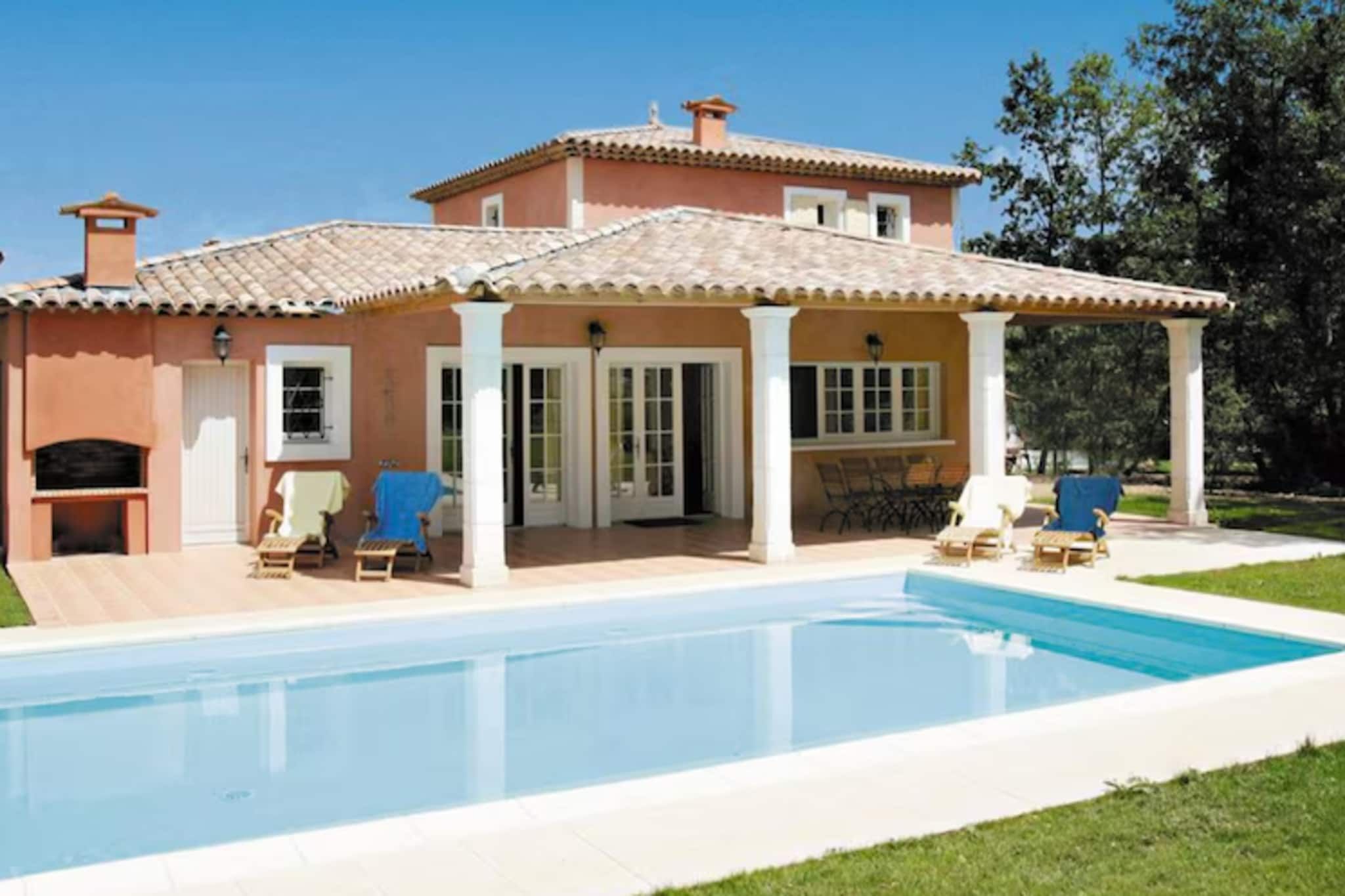 A two-story house with a swimming pool, outdoor seating, and a pergola.