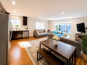 A modern living space with a kitchen, dining area, and seating area. - 2BR/2BA in Queen Anne | Near Downtown Seattle Center I AC and driveway parking (Seattle)