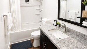 Un bagno moderno con vasca, WC, lavabo e un grande specchio.