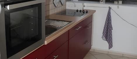 A kitchen with a built-in oven, microwave, and a coffee maker.