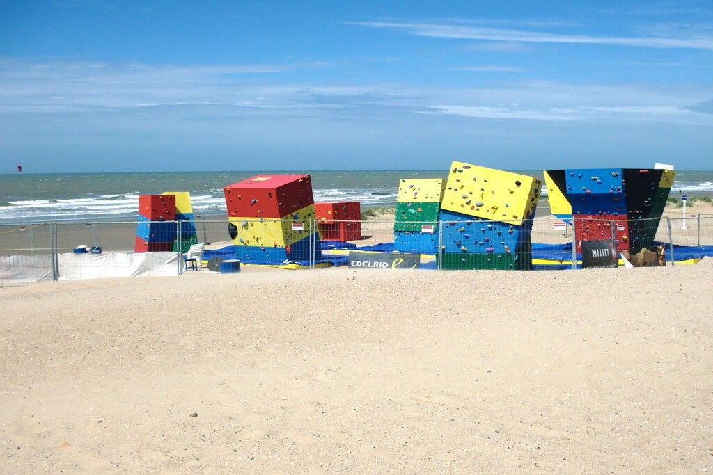 A beach with colorful climbing walls and a clear sky.