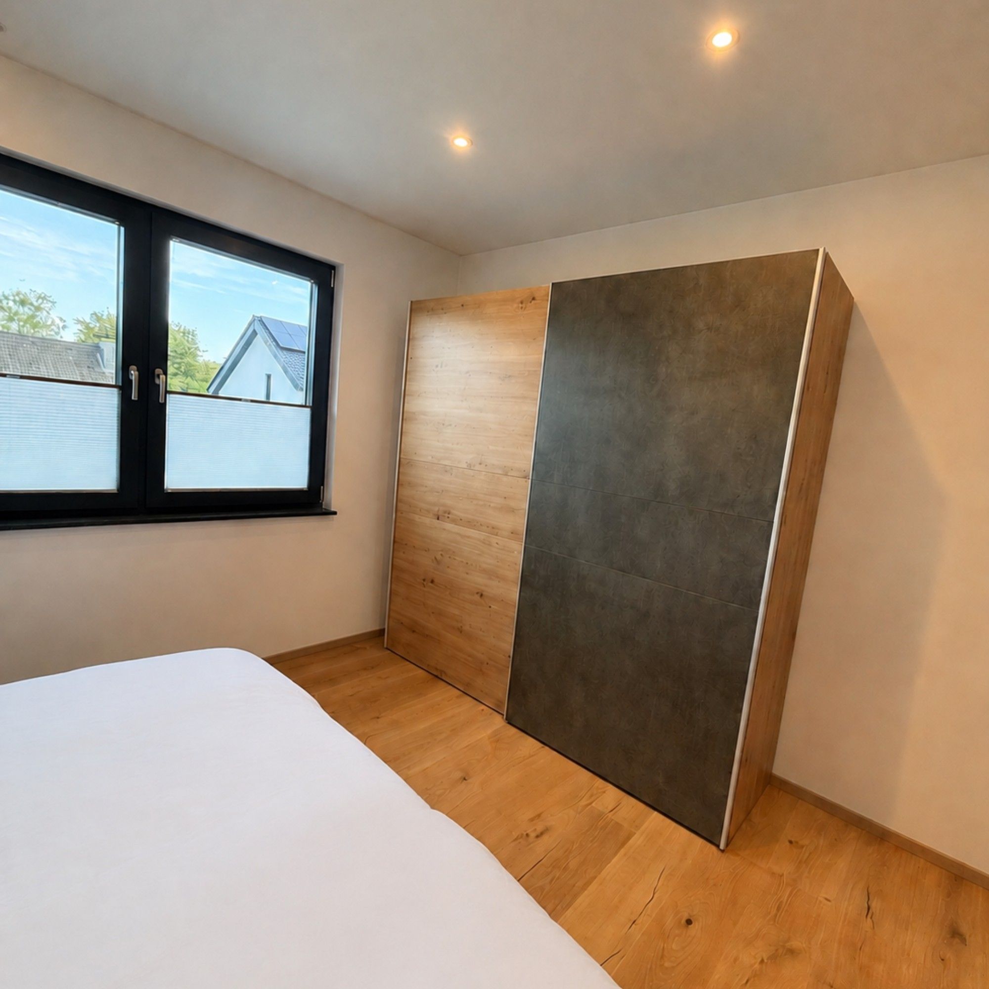 Una camera da letto con un letto grande, una porta scorrevole e una finestra vista casa.