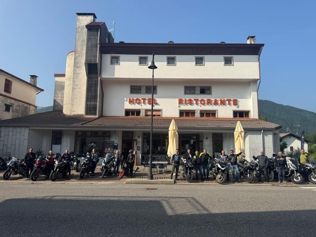 Un edificio con un cartello che riporta 'HOTEL RISTORANTE' e una fila di motociclette parcheggiate davanti.
