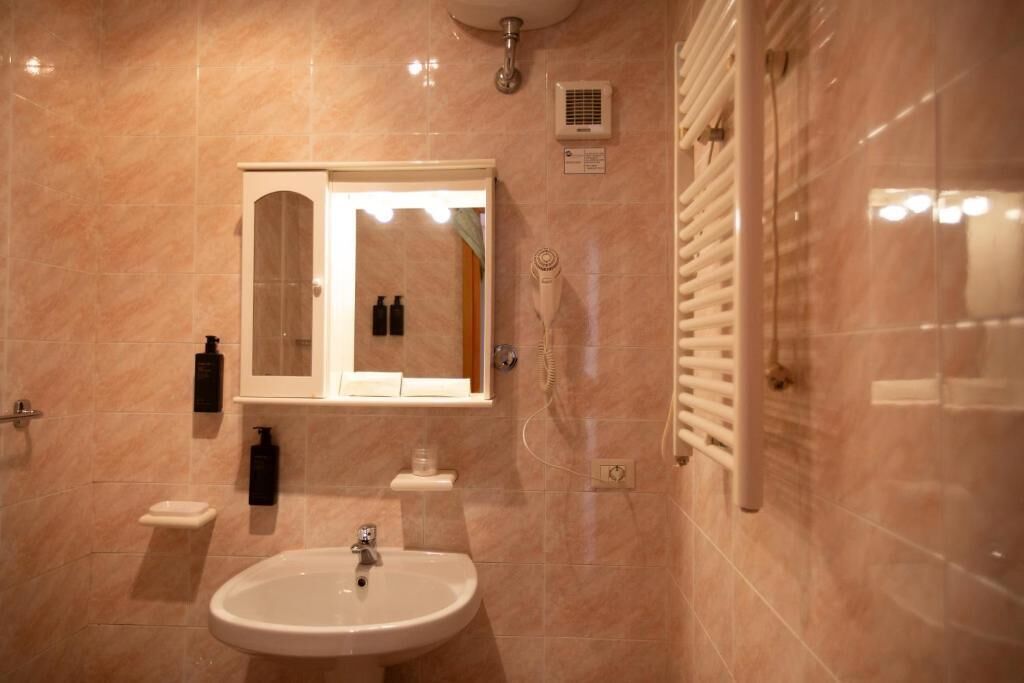 Un bagno con lavandino, specchio e doccia.