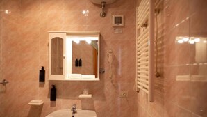 A bathroom with a sink, mirror, and shower. - Bike & Bikers Hotel (Ampezzo)