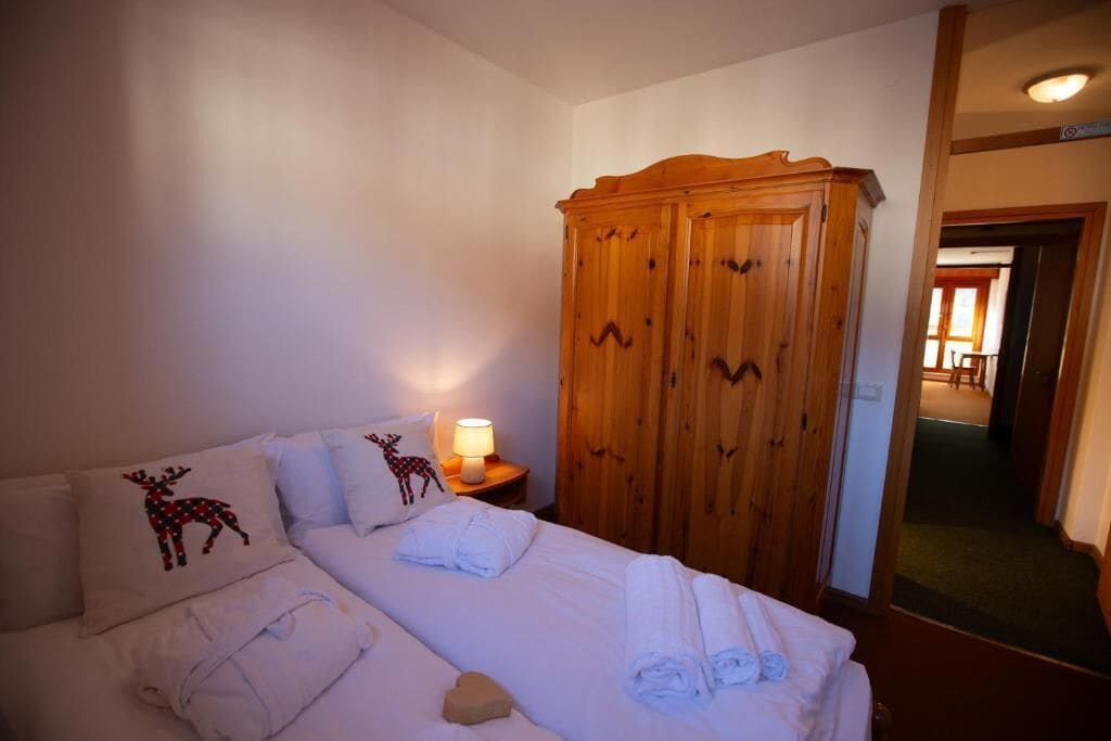 Ein Hotelzimmer mit einem Bett, einem Kleiderschrank und einem Nachttisch mit Lampe.