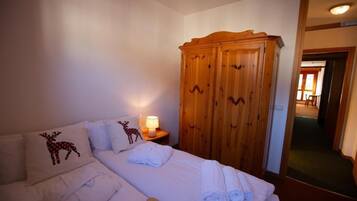 Ein Hotelzimmer mit einem Bett, einem Kleiderschrank und einem Nachttisch mit Lampe.