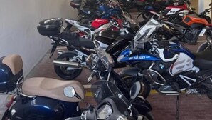 A parking garage with multiple motorcycles and scooters parked in rows. - Bike & Bikers Hotel (Ampezzo)