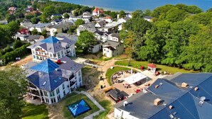 Un barrio residencial con casas, una piscina y vistas al mar.